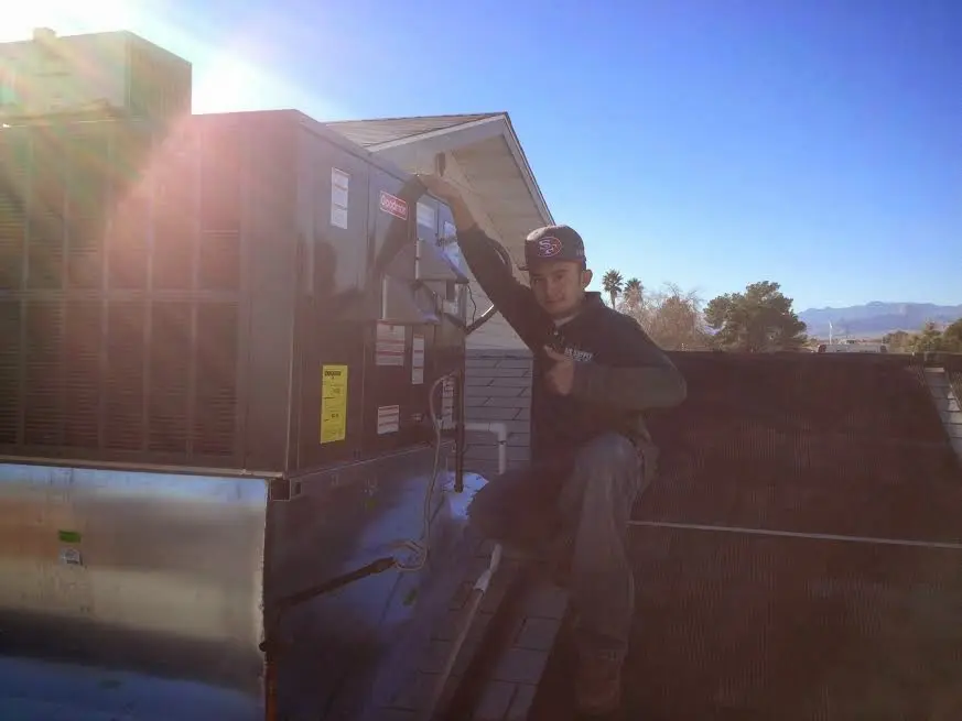 HVAC technician performing AC Tune-Up on a rooftop unit in Murrysville