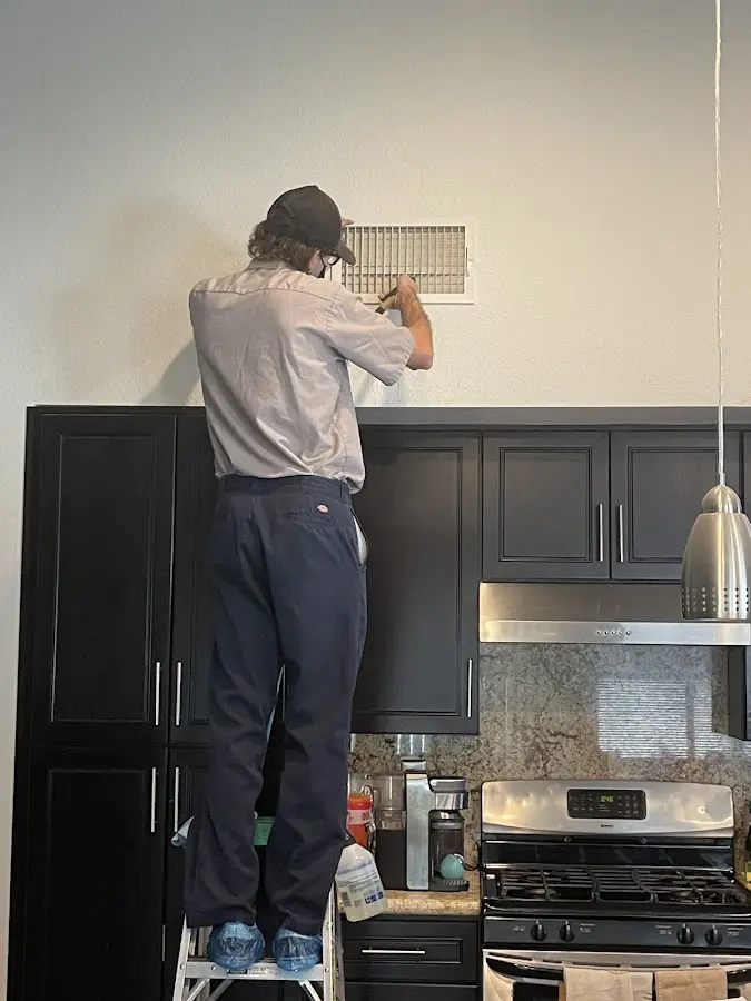 Technician inspecting an air vent during HVAC service in Murrysville